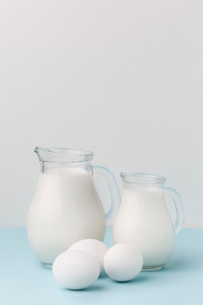 Uova organiche di vista frontale con brocche di latte