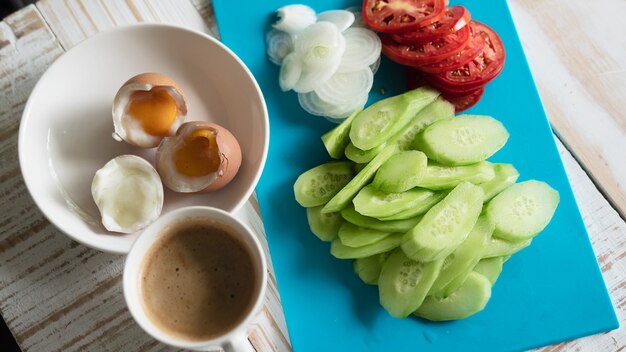 Uova sode con l&#39;insieme fresco della prima colazione della tazza di caffè e dell&#39;insalata del cetriolo - concetto dell&#39;alimento di prima colazione di vista superiore