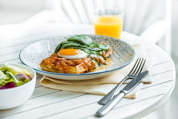 Uova strapazzate su carne con patate fritte e pane tostato