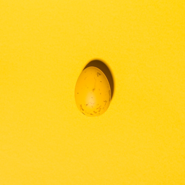 Uovo di Pasqua giallo sul tavolo giallo
