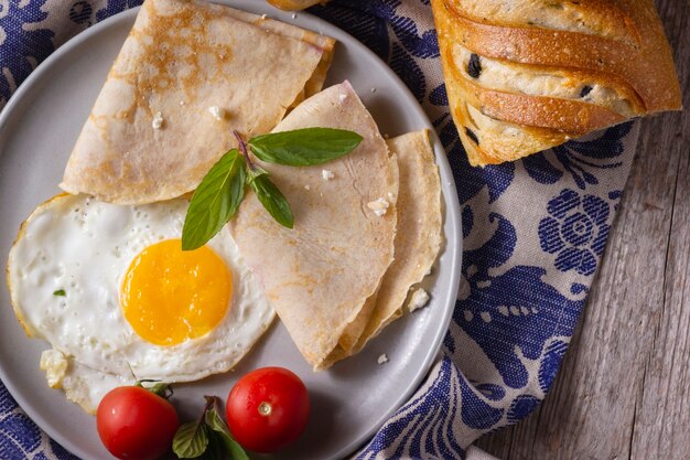 Uovo fritto con crepes e pomodori