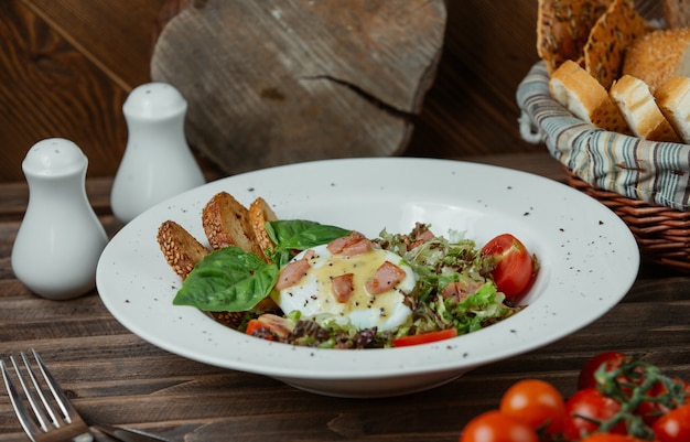 Uovo fritto in un piatto con toast e insalata verde