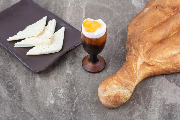 Uovo sodo con pane bianco fresco su fondo marmo. Foto di alta qualità