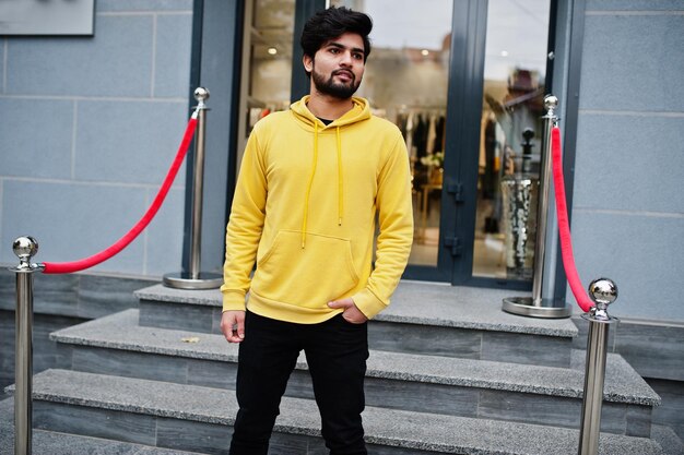 Urban giovane hipster indiano uomo in una felpa gialla alla moda Cool sud asiatico ragazzo indossare felpa con cappuccio