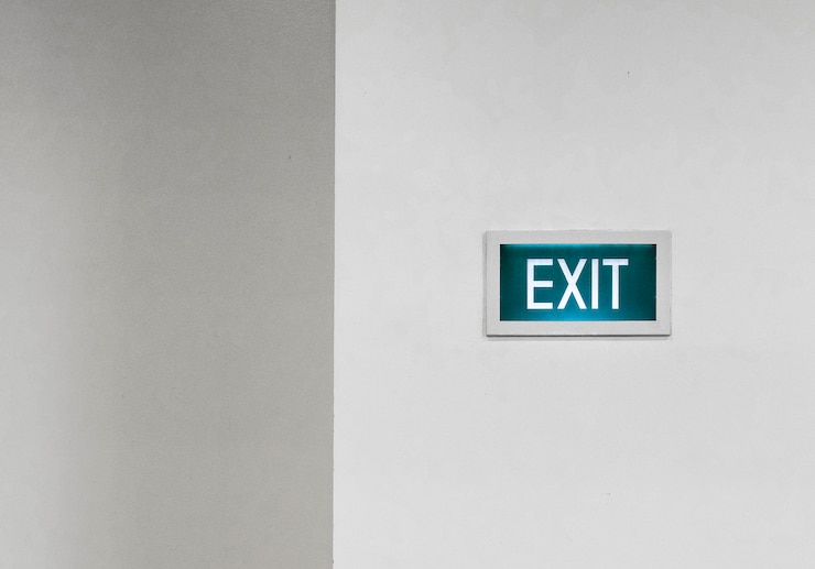 Foto gratuito uscita verde segno su un muro bianco