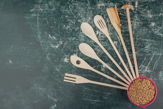 Utensili da cucina con con secchio di grano rosa su sfondo di marmo.