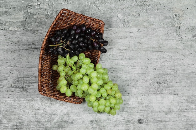Uva fresca in bianco e nero nel cestino di legno.