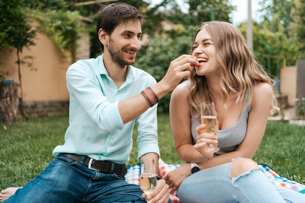 Vacanze estive, persone, romanticismo, concetto di appuntamenti, coppia che beve spumante mentre si gode del tempo insieme a casa nel cortile sul retro