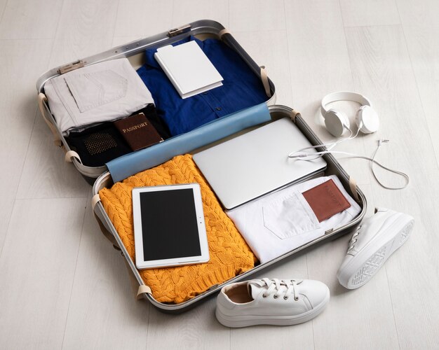Valigia con cuffie e passaporto per viaggiare