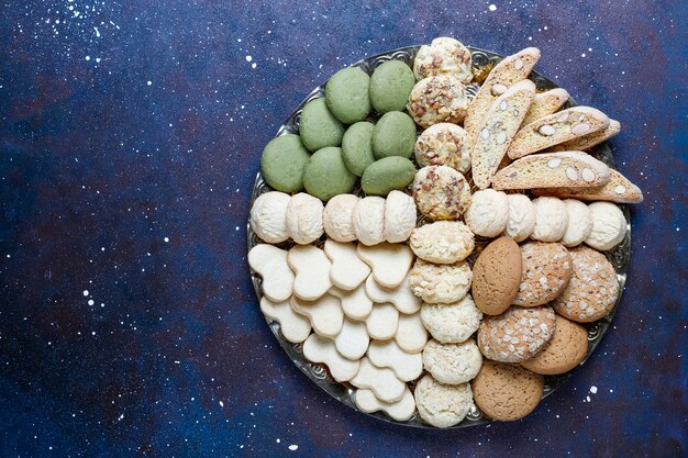 Vari biscotti in un vassoio di legno su fondo grigio