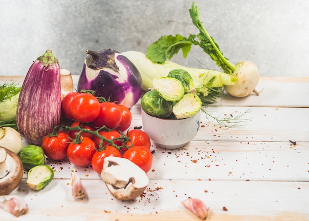 Varie verdure organiche fresche su superficie di legno