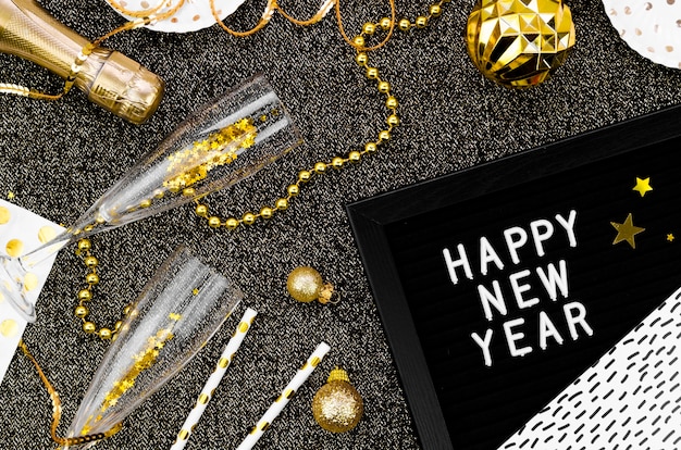 Varietà di accessori e vetri su fondo nero e ghirlanda del buon anno