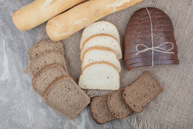 Varietà di alimenti freschi di pane su tela di sacco.