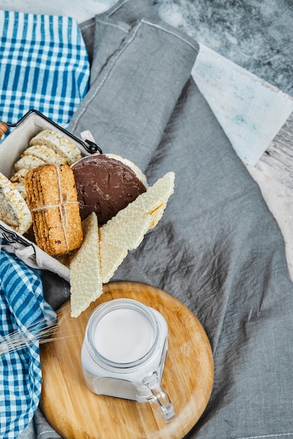 Varietà di biscotti e cracker con un barattolo di latte.