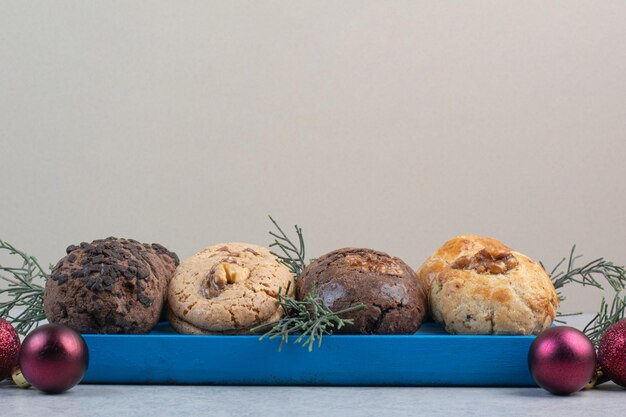 Varietà di biscotti sul piatto blu con le palle di Natale. Foto di alta qualità