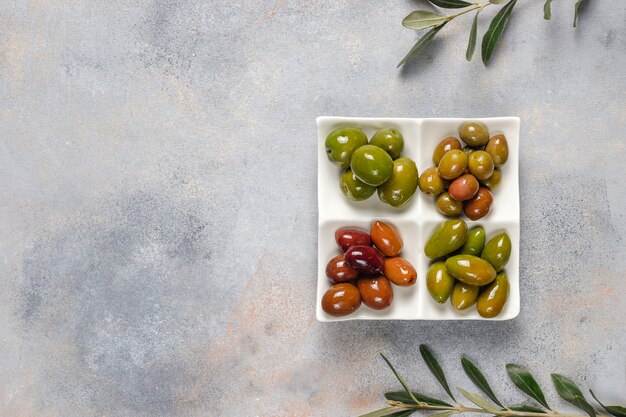 Varietà di olive intere verdi e nere.