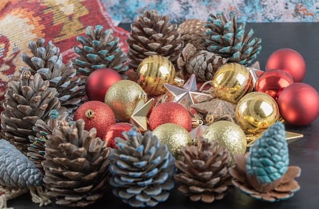 Varietà di ornamenti per alberi di Natale su un pezzo di tappeto etnico con motivo rosso