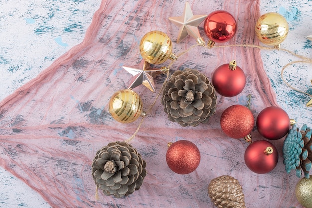 Varietà di ornamenti per alberi di Natale su un pezzo di tela da imballaggio sul blu strutturato
