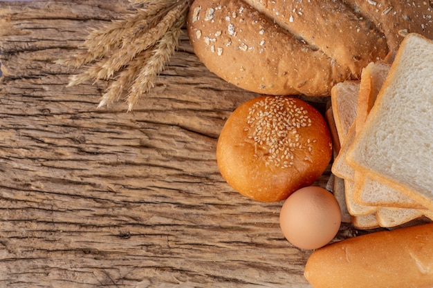 Varietà di pane sulla tavola di legno su un vecchio fondo di legno.