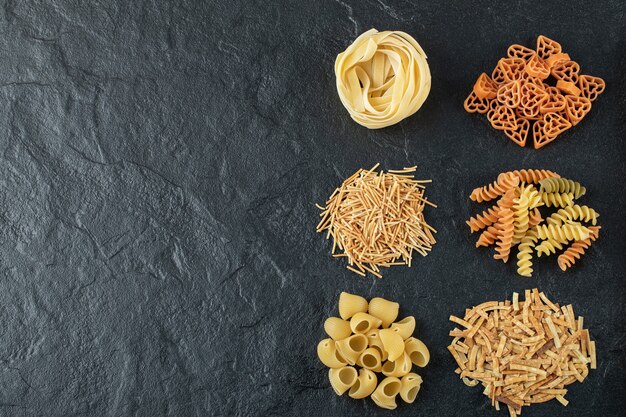 Varietà di pasta cruda sul nero.