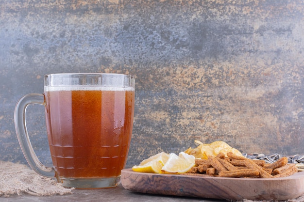 Varietà di snack e bicchiere di birra sul tavolo di marmo. Foto di alta qualità