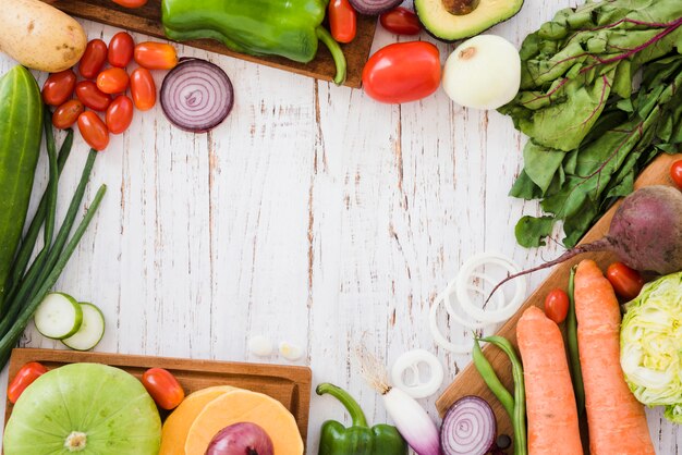 Varietà di verdure biologiche sulla scrivania in legno bianco