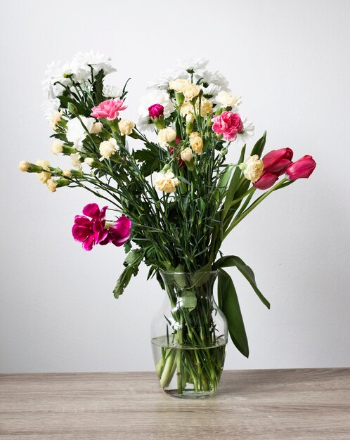 Vaso alto angolo con fiori che sbocciano