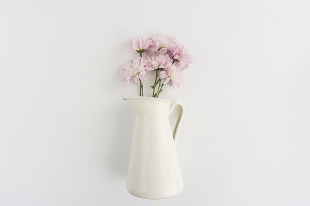 Vaso con fiori sulla superficie bianca