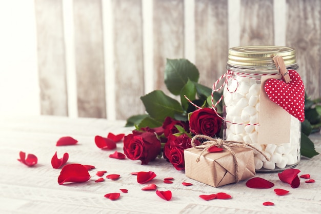 Vaso con marshmallow, regalo e bouquet di rose. Amore, dolce o