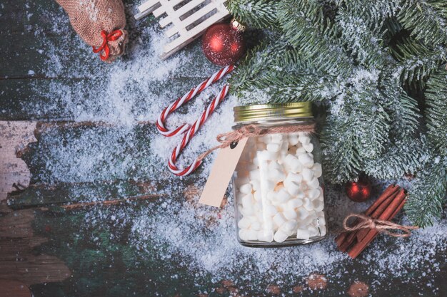 Vaso con marshmallow su neve e le decorazioni di Natale