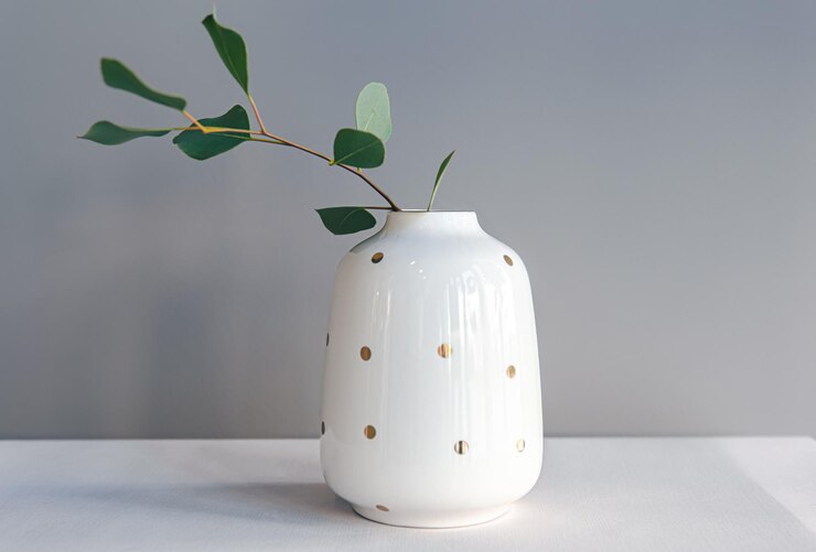 Foto gratuito vaso decorativo bianco con pois su sfondo chiaro isolato