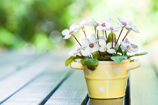 Vaso di decorazione artificiale bel fiore in cima al tavolo per biglietto di auguri