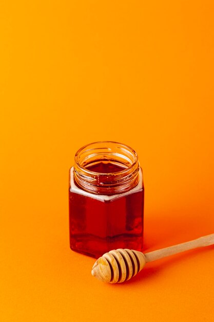 Vaso e mestolo del miele dell'angolo alto con lo spazio della copia