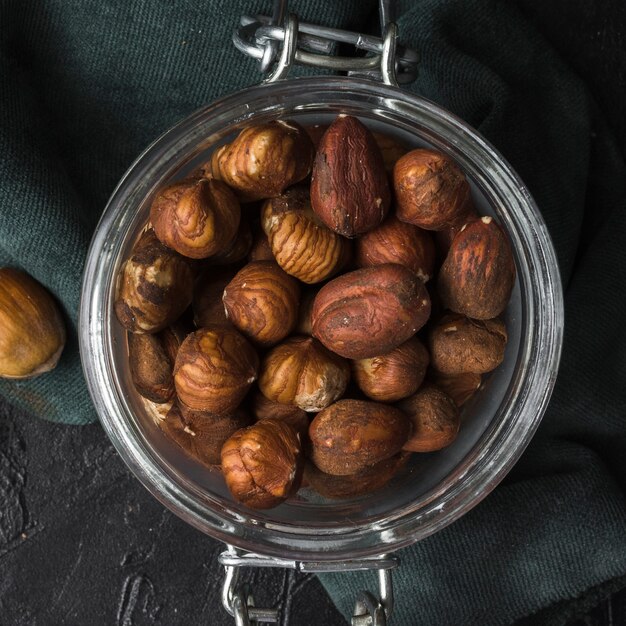 Vaso pieno di nocciole secche close-up