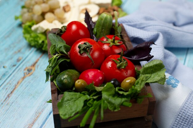 Vassoio di verdure con pomodori, cetrioli ed erbe.