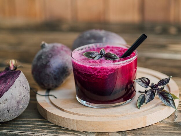 Vassoio in legno con bicchiere di succo di barbabietola