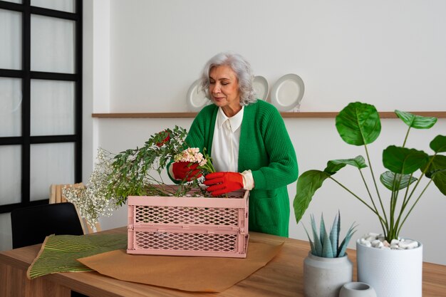 Vecchia donna media che si prende cura delle piante