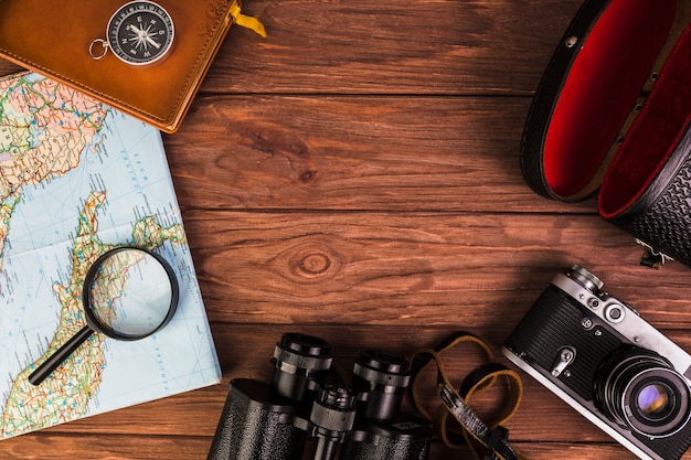 Vecchia roba di viaggio alla moda sul tavolo di legno