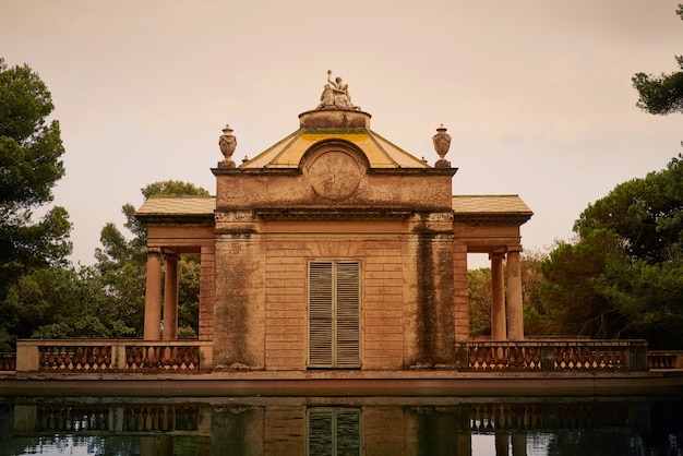 Vecchio bellissimo edificio del parco che riflette in uno stagno