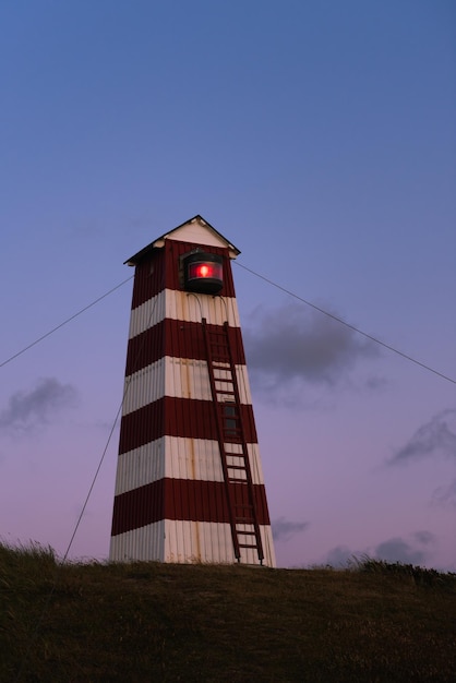 Vecchio faro in Danimarca sotto un bel tramonto