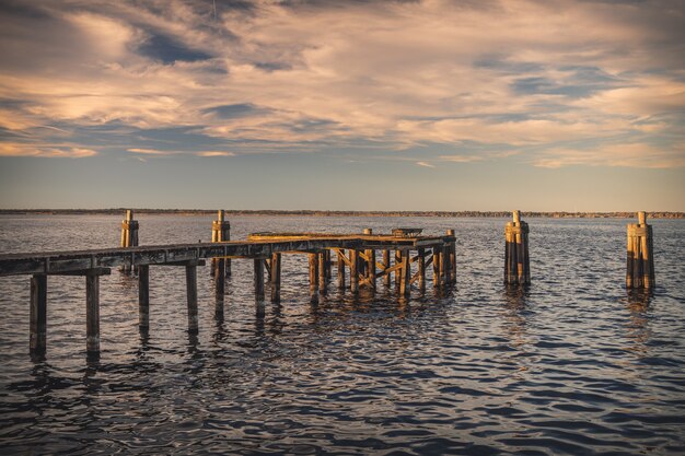 Vecchio molo di legno sul mare sotto la luce del sole durante il tramonto