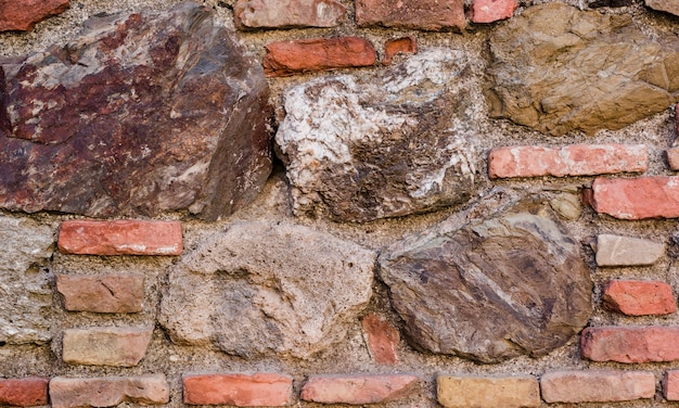 Vecchio muro di mattoni con pietre