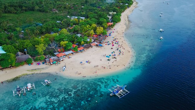 Veduta aerea della spiaggia sabbiosa con i turisti che nuotano in bella acqua cristallina della spiaggia dell&#39;isola di Sumilon che atterra vicino a Oslob, Cebu, Filippine. - Aumentare la lavorazione del colore.