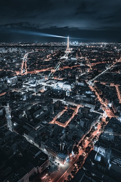 Veduta aerea di una torre Eiffel e densi edifici con luci illuminate di notte