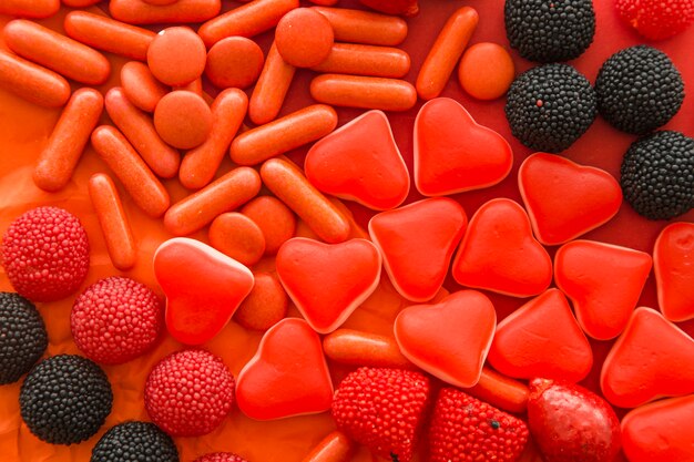 Veduta dall&#39;alto di frutti di bosco, caramelle a forma di cuore e capsule