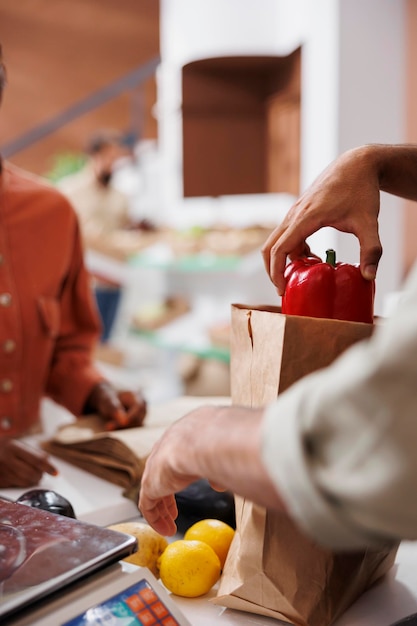 Venditore che imballa cibo coltivato localmente in sacchetto