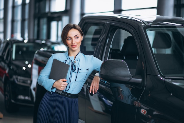 Venditore femminile in una sala d&#39;esposizione dell&#39;automobile