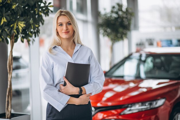 Venditore femminile in una sala d&#39;esposizione dell&#39;automobile