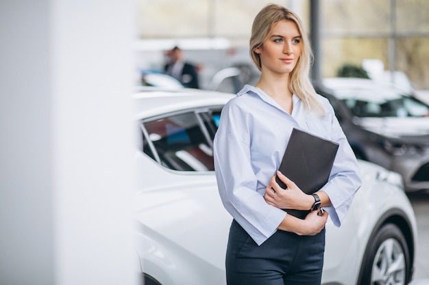 Venditore femminile in una sala d&#39;esposizione dell&#39;automobile