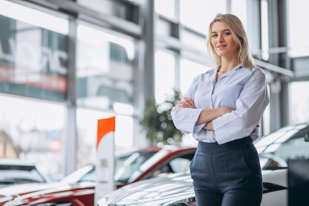 Venditore femminile in una sala d&#39;esposizione dell&#39;automobile